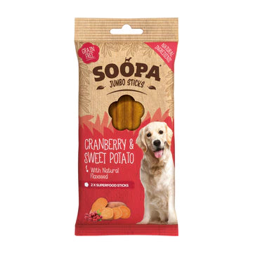 A package of Soopa Jumbo Cranberry & Sweet Potato Sticks for dogs. The sticks are made with natural ingredients, flaxseed, and are grain-free. The package shows a dog holding one of the sticks, with cranberries and sweet potatoes in the background.